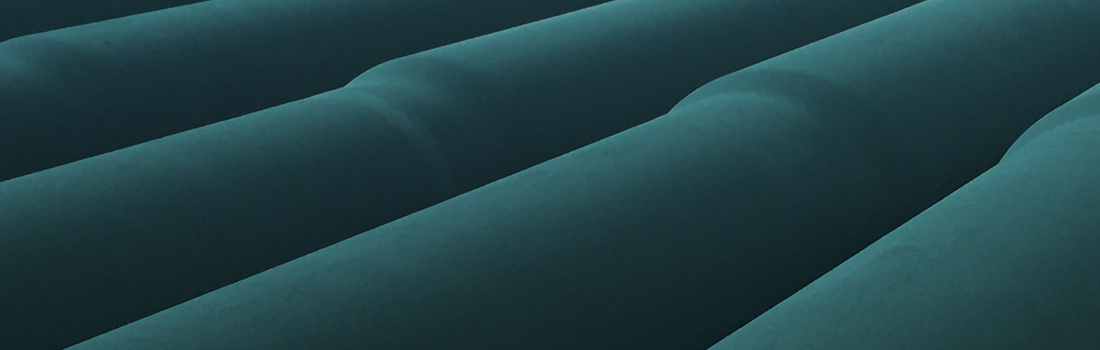 Mehrere beschichtete Rohre liegen nebeneinander.