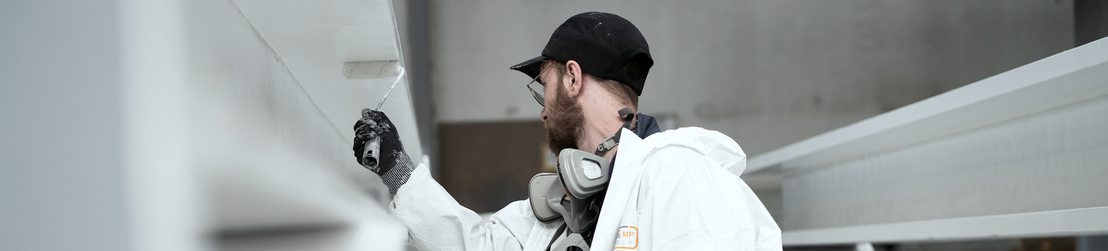 Mitarbeiter kontrolliert die fachgerechte Ausführung einer Brandschutzbeschichtung.